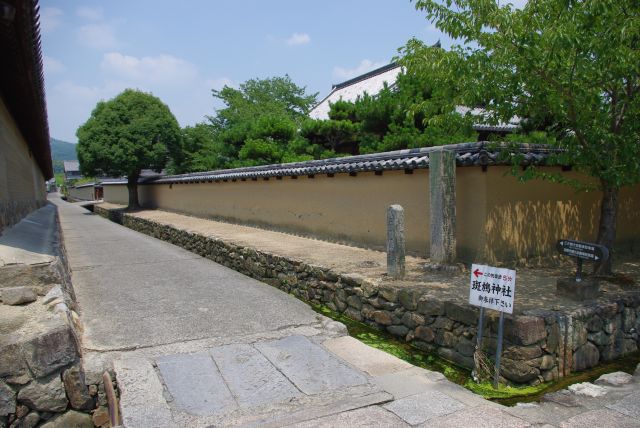 通りの左の脇道。寺院の壁が続く。