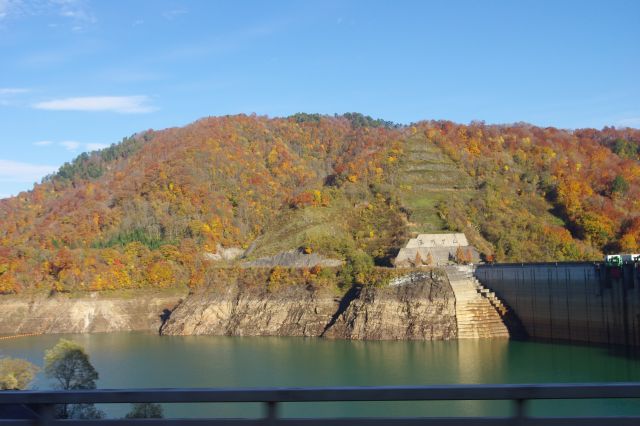 玉川ダムへ。貯水量はかなり少ないようで、紅葉の山の下には地層のような岩肌が露出しています。