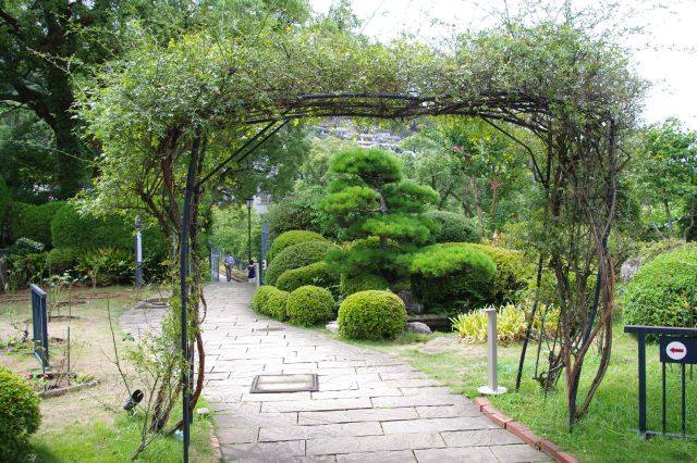 洋風庭園に松の木、池等の和洋折衷の庭・通路。