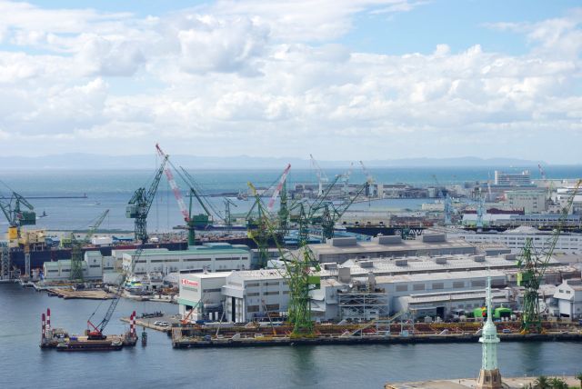 南側は川崎重工の造船所等の工場群。海の先に紀伊半島。
