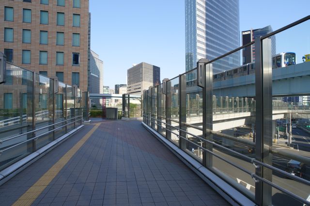 フェンスが透明で開放的な歩道橋を進みます。