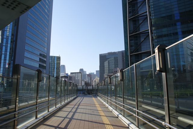 高層ビルに囲まれた立体交差する開放的なデッキは未来的です。