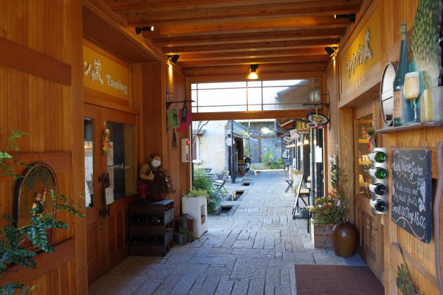 長屋の中央部から石畳の通路。木のぬくもりがある店舗。