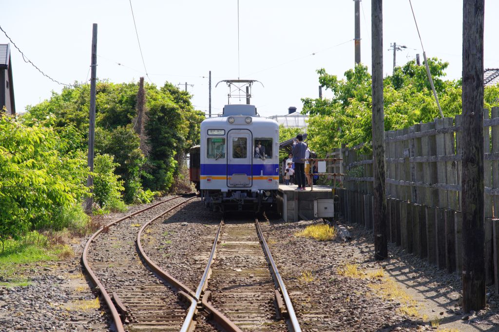 銚子電鉄・外川駅付近の踏切から見る駅に停まった電車