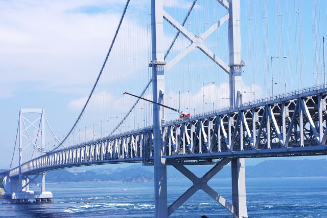 吊り橋からクレーンが橋脚へと何かを吊るしています。ちょっと珍しい風景？