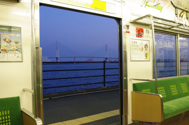 電車の中から。シートに座った状態でもすぐ海と橋が見える、本当に珍しい場所。