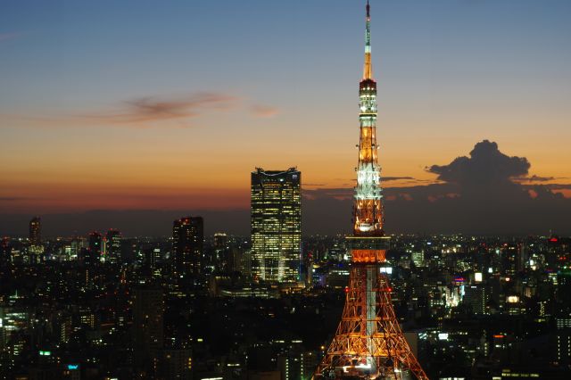 東京タワーと六本木ヒルズ方面の夕景。地平線付近は夕空、その上は青い夜空と、ダイナミックなグラデーションを描いている。