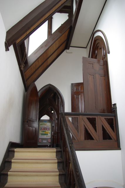 教会の中の階段部分。白い壁に木製の扉・柱。