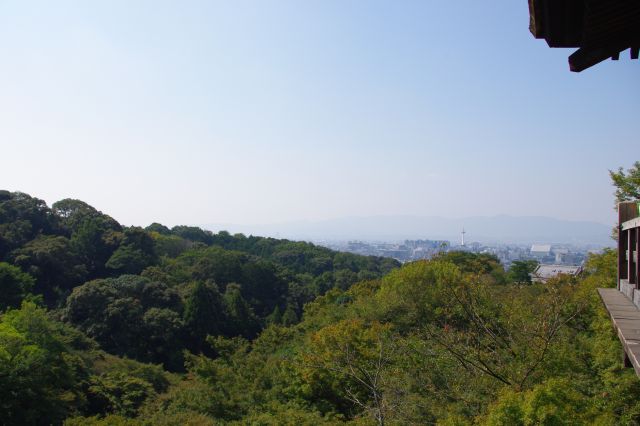 有名な清水の舞台より京都方面を眺める。周囲はたくさんの自然に囲まれていて、奥には開けた市街地が見える。