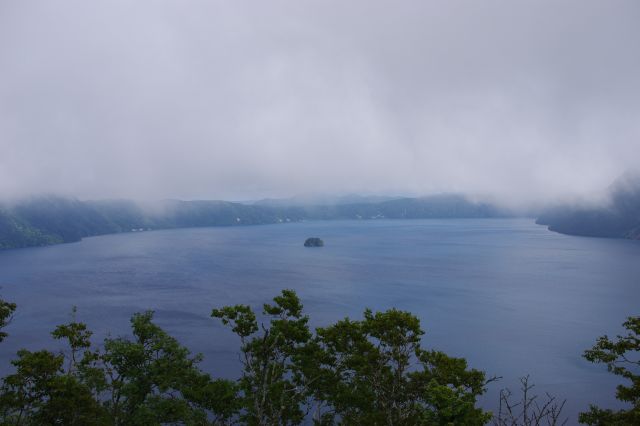 霧に覆われた摩周湖。湖へは展望台からは急斜面の下。中に小さな島が見えました。