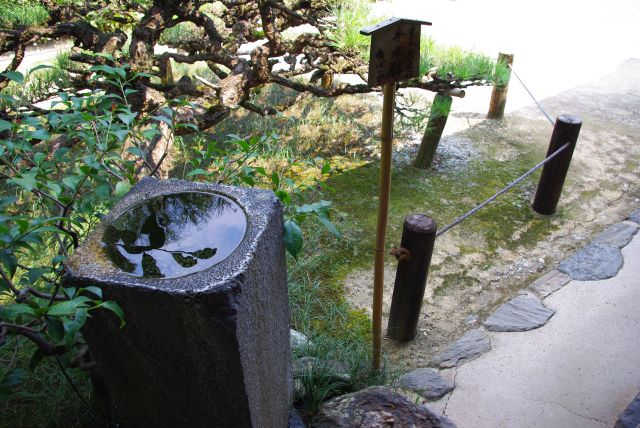 書院より茶菓子を食しながら庭園と奈良盆地を望む。見えづらいが遠くには山並みも見え、垣根の１つとしてみなされている。