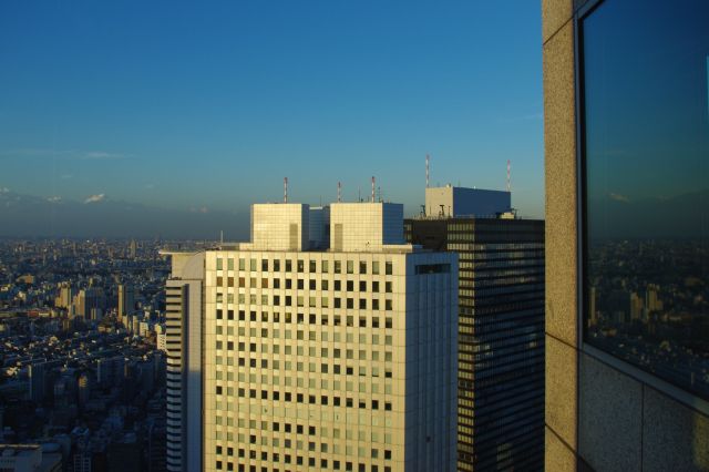 北東側にはすぐ近くに200mを越える新宿住友ビル、新宿三井ビルが並ぶ。