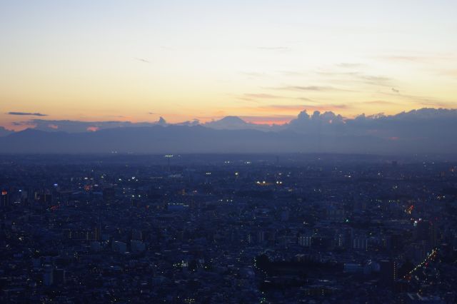 陽が沈み、街の灯かりも目立ち始め、富士山のシルエットが見えるようになりました。
