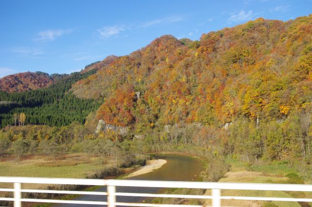 川沿いに鮮やかな紅葉の山が続いていきます。