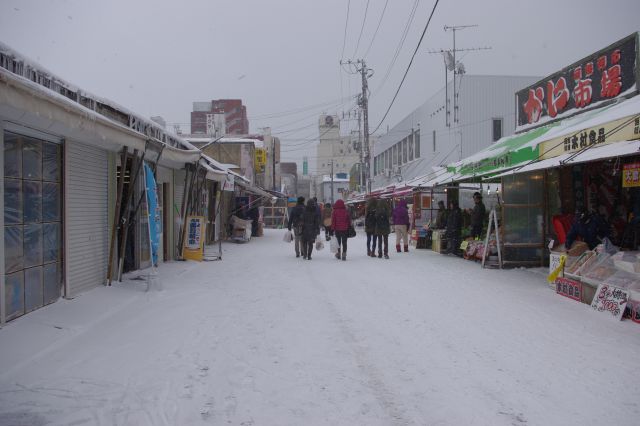 雪の中の市場にたくさんの人が訪れる。