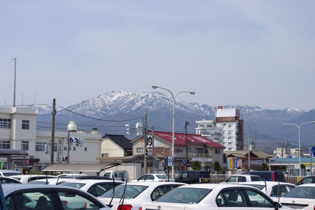 雪の残る標高1172mの金北山。港はバスやタクシーが多く、加茂湖との間の両津湊の街が続く。