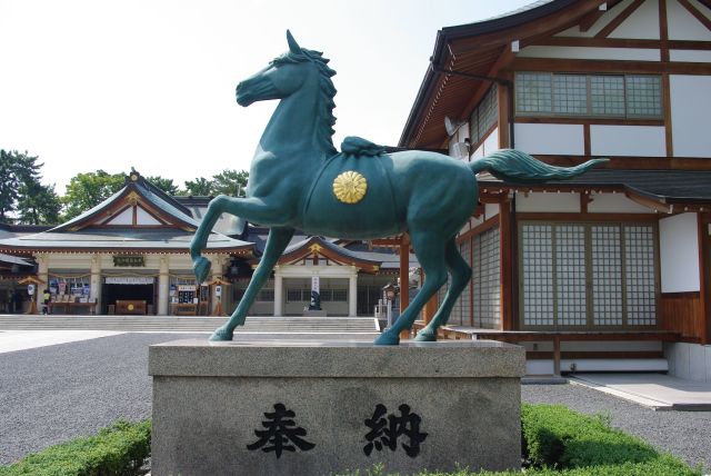 鳥居の横に印象的な青い馬の像。