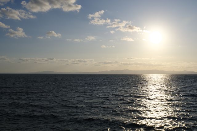 太陽の方へ。うっすらと山並みが連なる津軽半島。