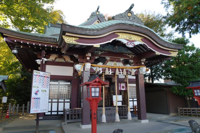 階段の上に鎮座する拝殿。左奥に参道の緑。