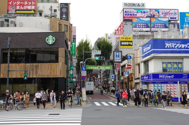 飯田橋駅西口付近、外堀通り・神楽坂下交差点から神楽坂通りへ進みます。チェーン店が多く、沢山の人が行き来します。
