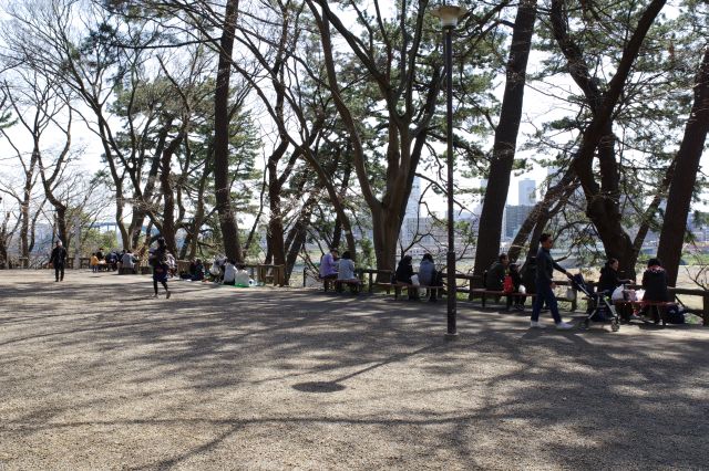 南東側へ。川沿いの展望を楽しむ人々。橋を渡る電車の音が響きます。
