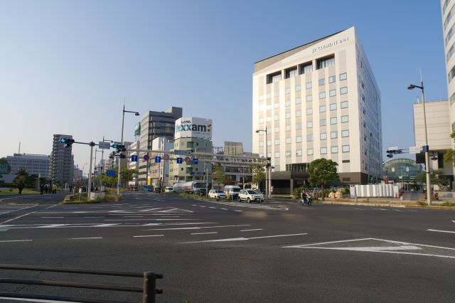 交差点より。左に高松築港駅があり、右にJR高松駅が「顔」を出します。
