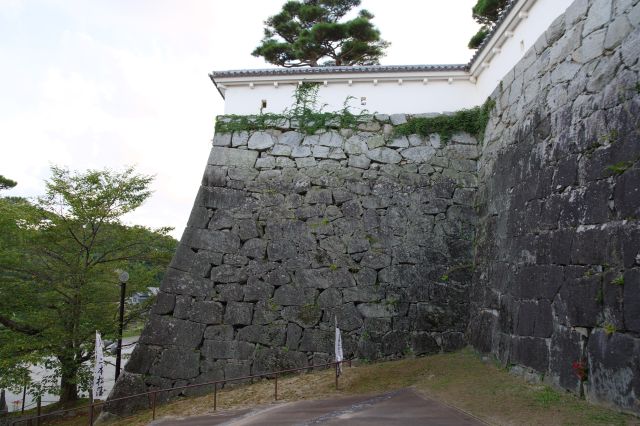 高い石垣と狭間のある塀。