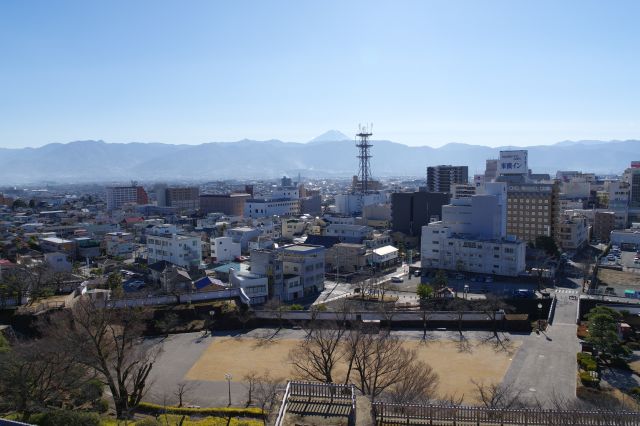 南側へ、町並みと山並の先に富士山が顔を出します。