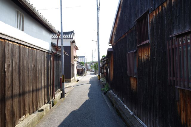 黒い木の壁が迫る路地。