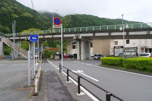 斜めの陸橋の下が入口。右には広い駐車場。