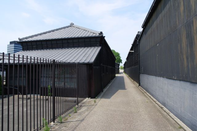 小路の両側に黒壁が迫る情景。