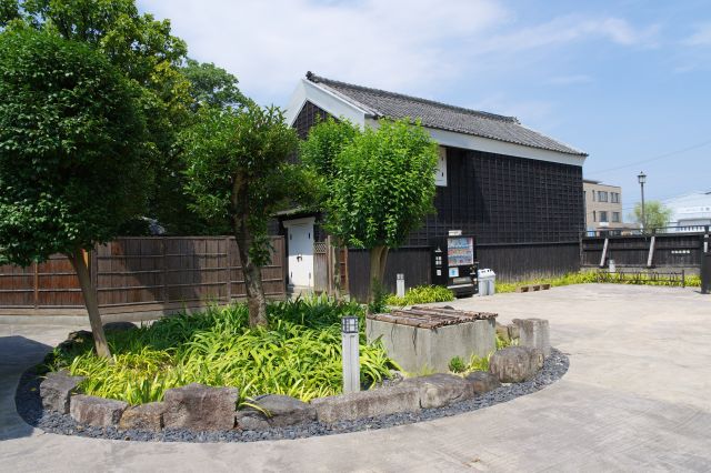 中心の井戸や水鉢、奥に黒い蔵も。