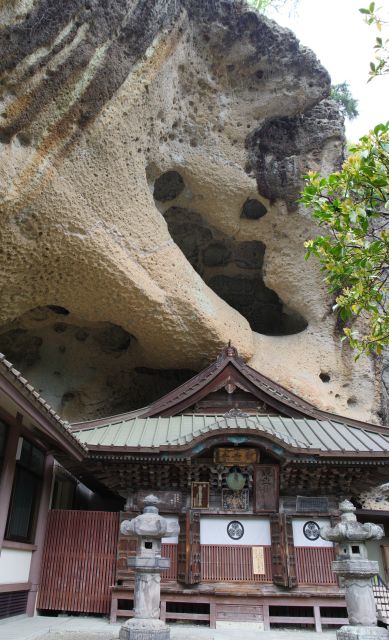 観音堂の上に迫力ある見上げる岩が覆う。