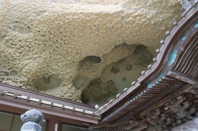 建物を覆う頭上の岩。