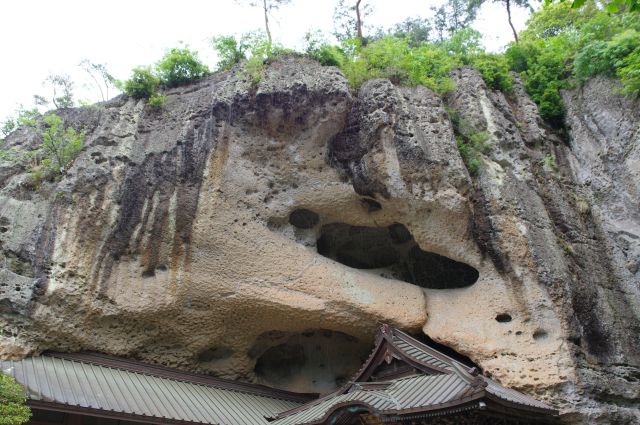 離れた所から見る観音堂の頭上を覆う岩。