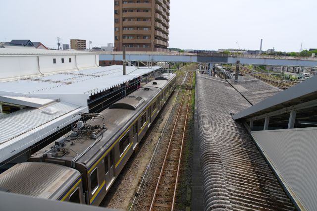 東側、奥は銚子電鉄が東へ継ぎます。駅舎前から歩道橋が跨いでいます。
