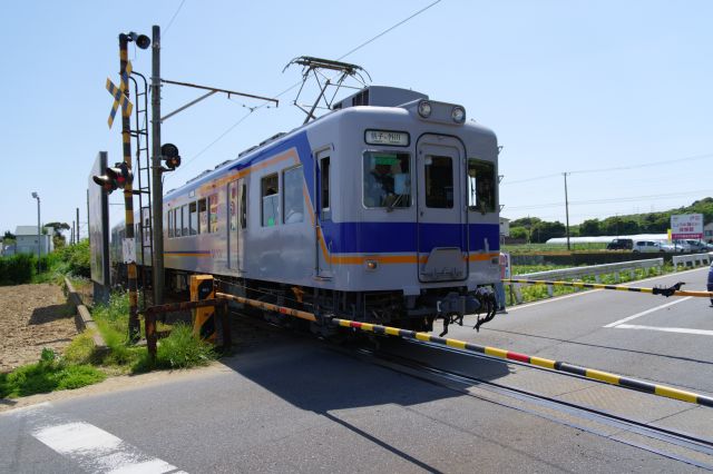外川から来て踏切を渡る列車、今度は別のカラーの車両。