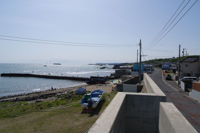 右側に小さくて静かな長崎漁港、海が太陽で輝く。