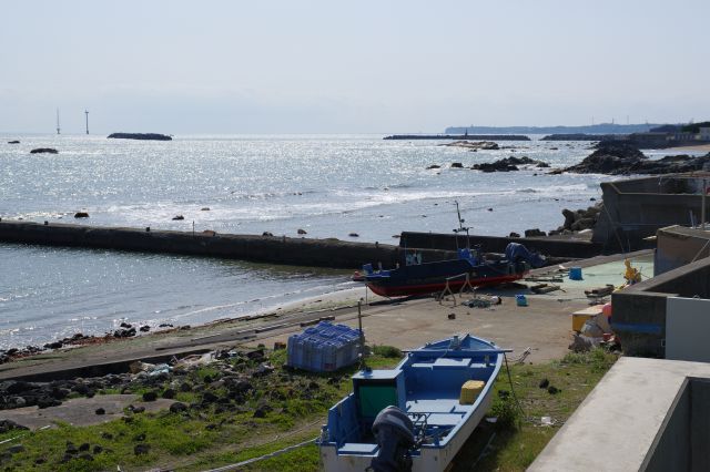 今は静かな漁港と輝く海。