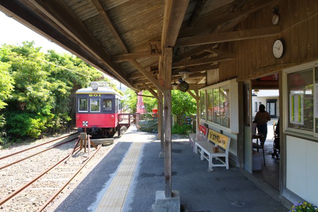 屋根のある駅舎前へ、駅舎には人の存在感があります。