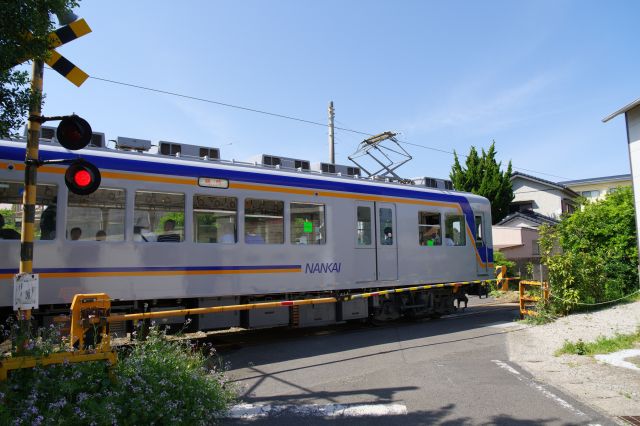 2番目の踏切、臨時幕になって戻って来た列車が通ります。