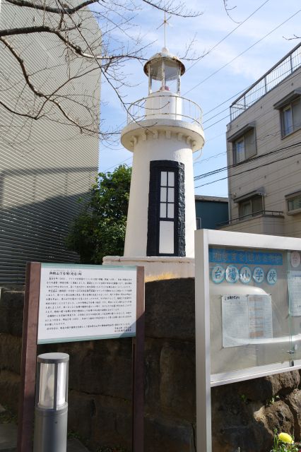 校門脇には石垣の真鶴石と第2台場にあった品川灯台（重文）のレプリカがあり歴史を伝えます。